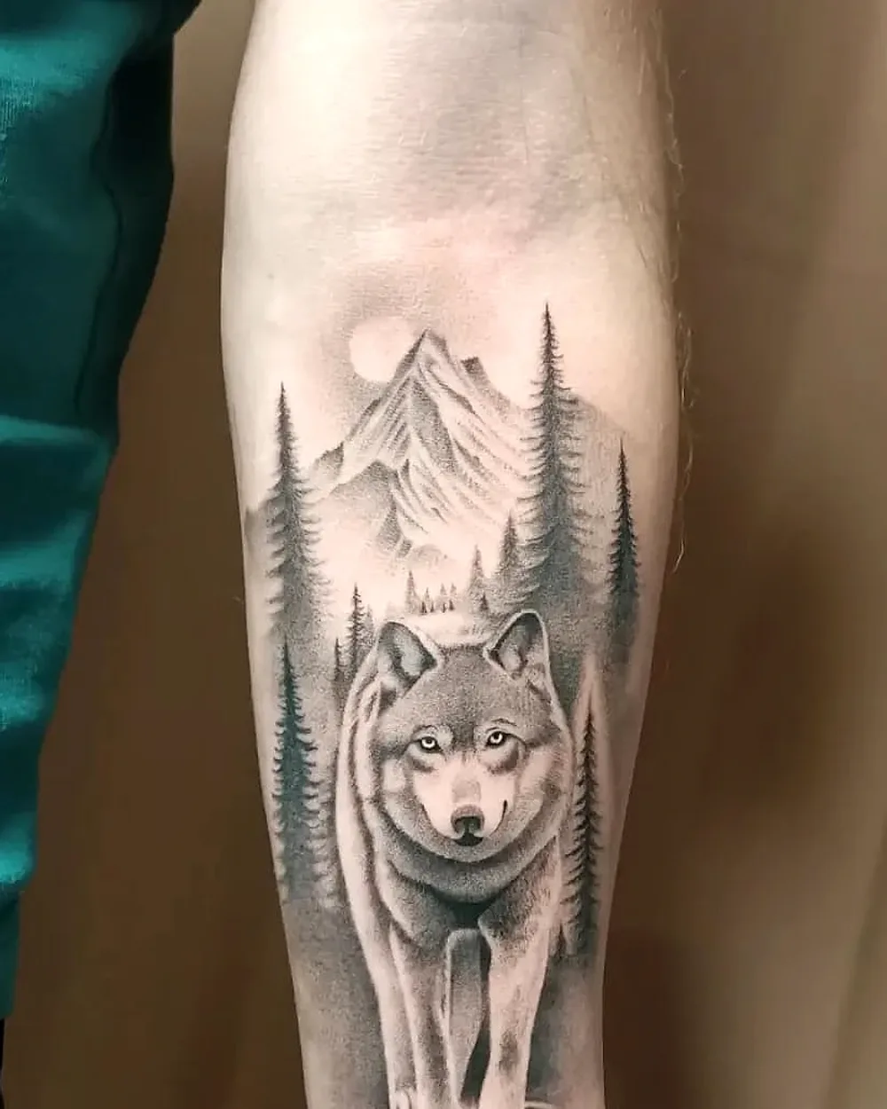 Tatouage réaliste loup, forêt de montagne et reflet sur l'avant-bras, ProSkin-R Cahors