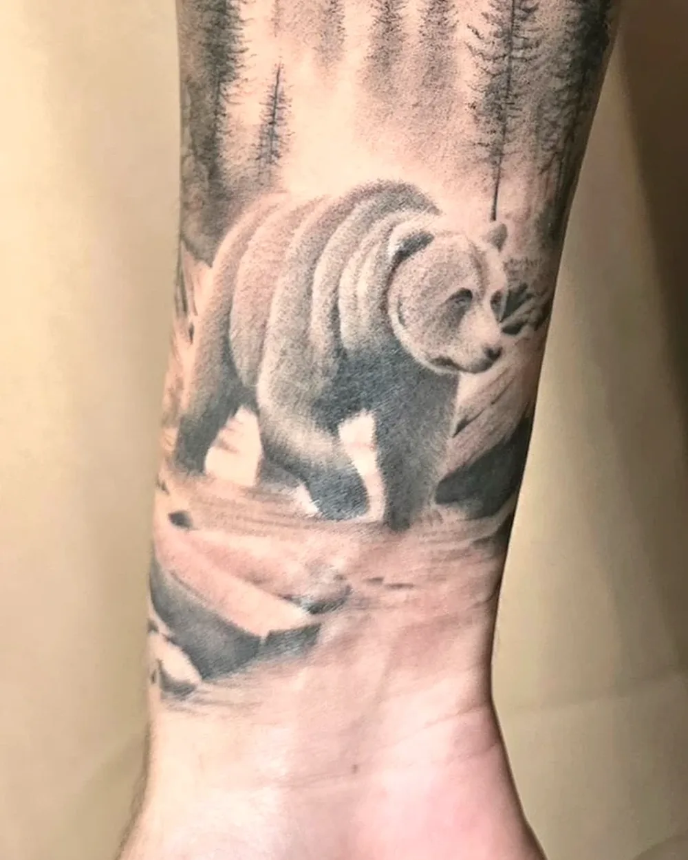 Tatouage réaliste ours en forêt sur l'avant-bras, noir et gris, ProSkin-R près de Cahors