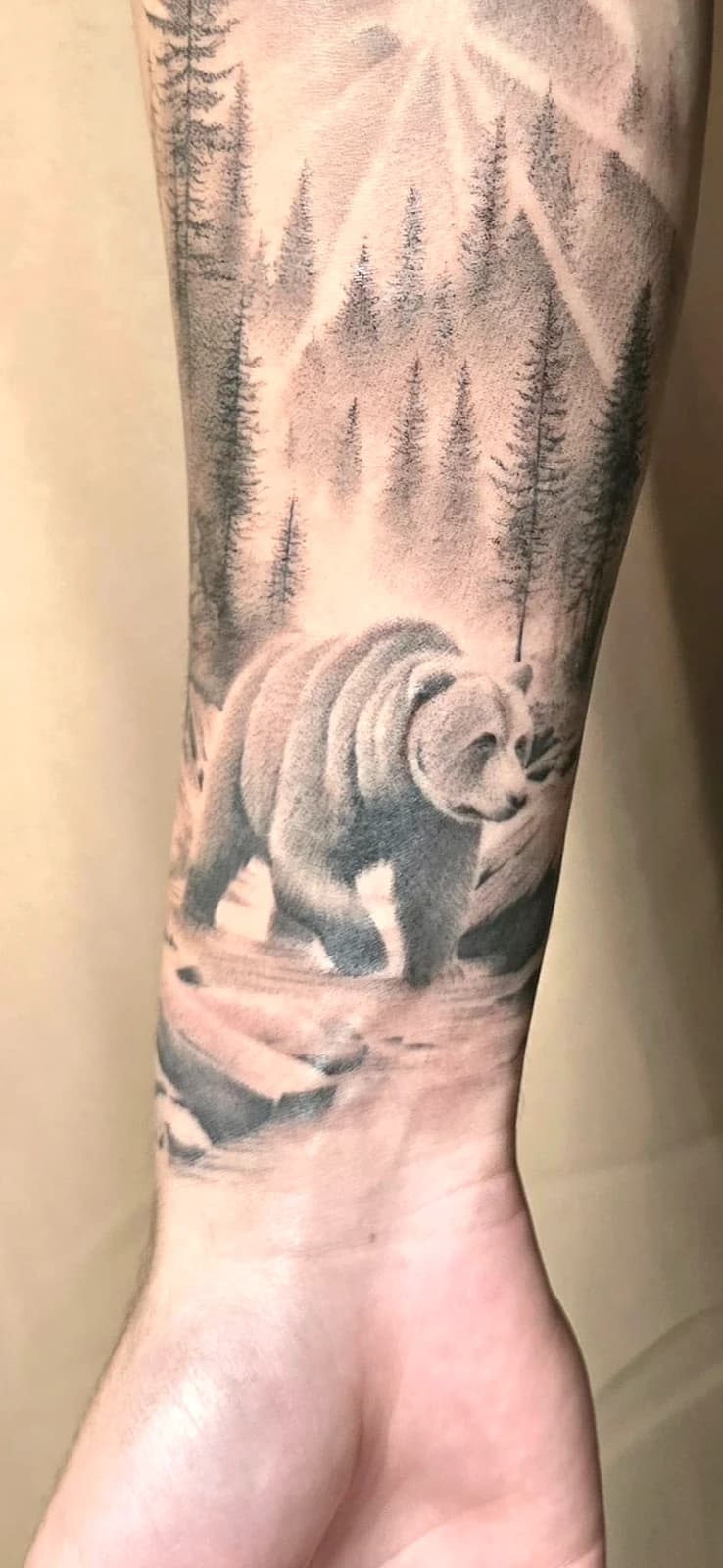 Tatouage réaliste ours en forêt sur l'avant-bras, noir et gris, ProSkin-R près de Cahors